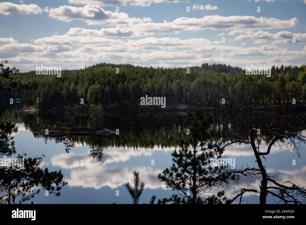 Finnische Seenlandschaft im Sommer mit der Reflexion auf See und Wolken am Himmel. Repovesi-Nationalpark in Kouvola Stockfoto