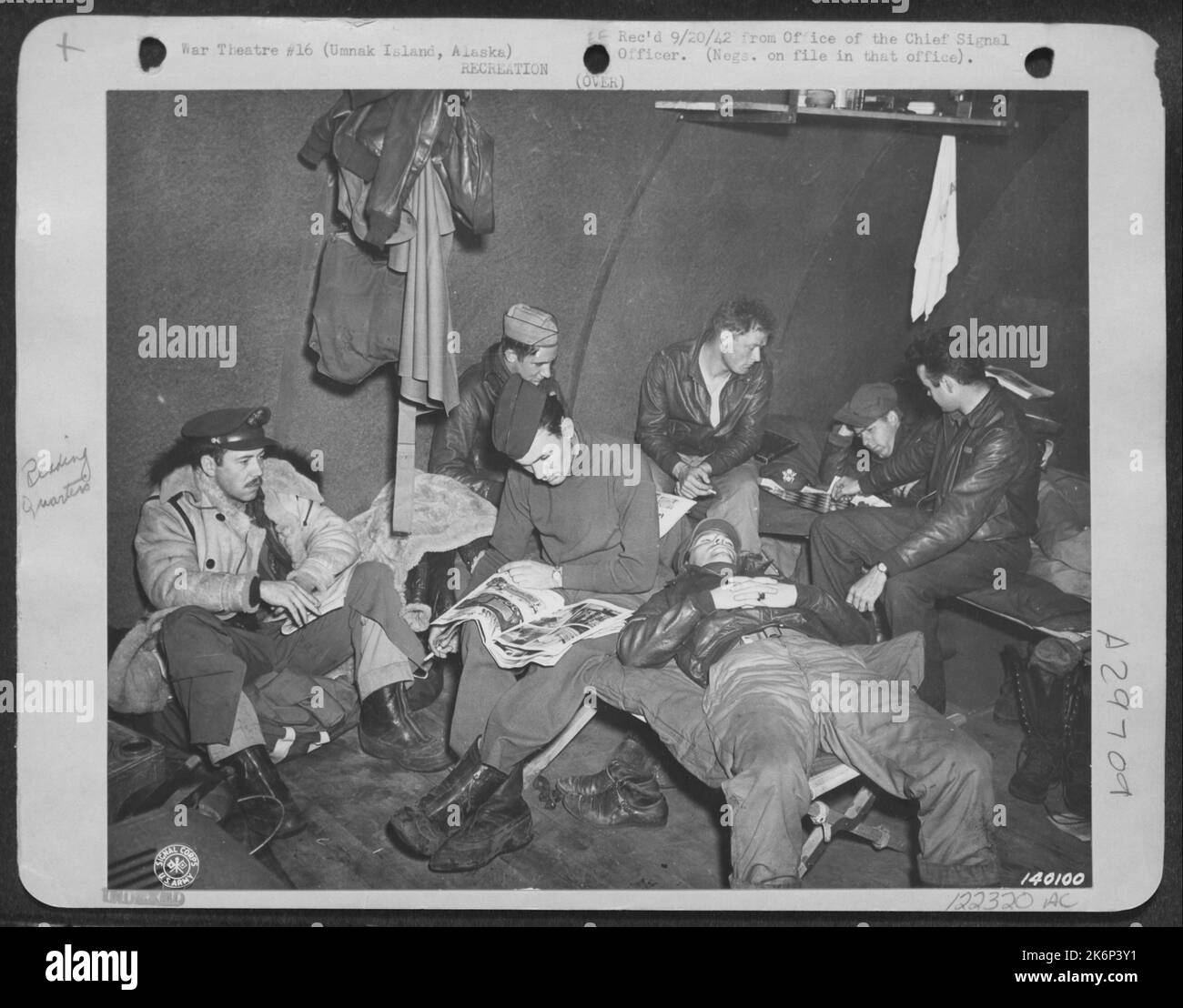 Piloten und Navigatoren entspannen sich in den frühen Morgenstunden und warten darauf, bis sie zur B-24S für Einen Bombenangriff auf die Japaner in Kiska gehen. Die Hütten Sind Warm, Aber Einige Der Männer Haben Ihre Flying Jackets Bereits An. Stockfoto