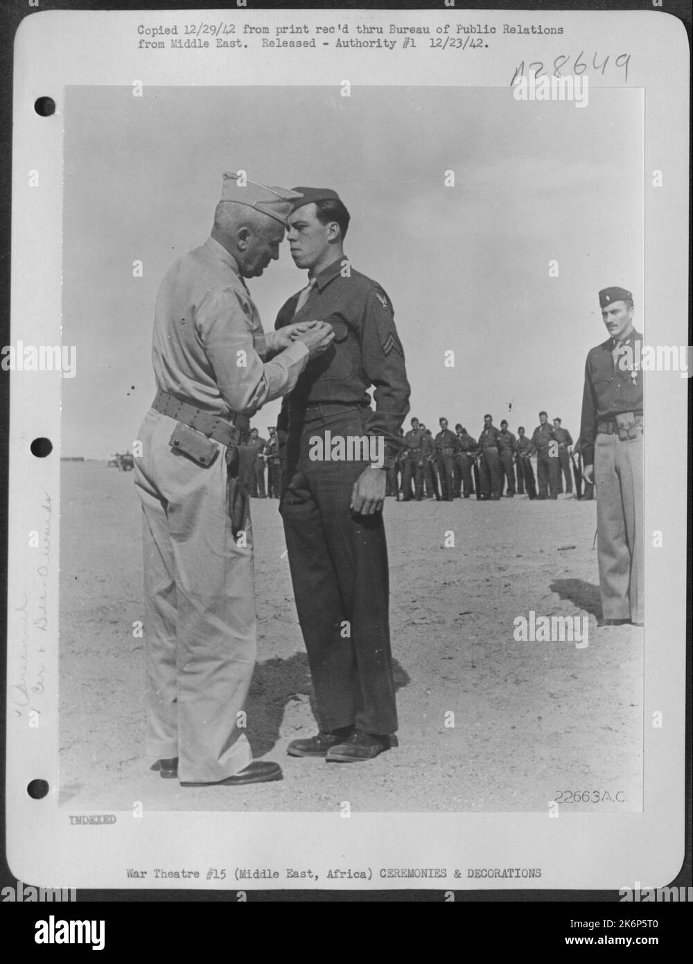CPL. Henry L. Walters steht zur Aufmerksamkeit, während Generalleutnant Frank M. Andrews, kommandierender General der U.S.A. F.I.M.E., den Orden des Purple Heart auf seine Brust pinnt. Die Dekoration wurde für Wunden, die während des Luftkampfes mit dem Feind erhalten wurden, präsentiert Stockfoto