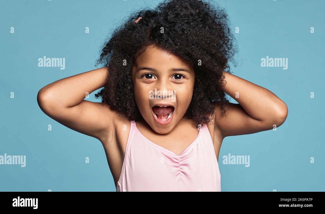 Portrait, schwarzes Mädchen Kind und aufgeregt überrascht, schockiert und berühren Haare mit blauen Studio-Hintergrund. Wow, afroamerikanische junge oder Stockfoto