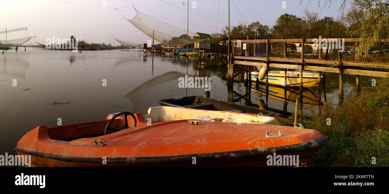 Rotes Boot mit Fischerhütten im Hintergrund (Porto Corsini) Stockfoto