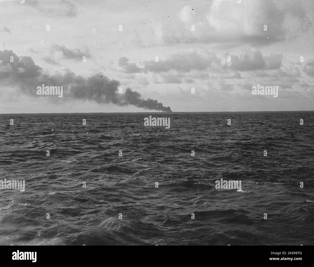 Foto der Verbrennung von Benzinstaub auf Makin Island nach Marine Commando RaidVerbrennung von Benzinstaub auf Makin Island nach Marine Commando Raids. Aufgenommen von der USS Nautilus (SS-168), die darauf wartet, die Marine von der Insel zu nehmen. Stockfoto