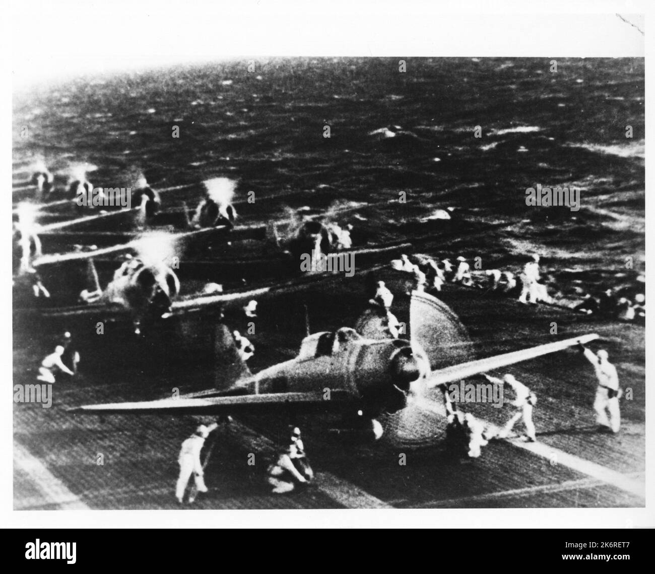 Erfasstes japanisches Foto von japanischen Mitsubishi Divebombers, die sich vor dem Angriff auf Pearl Harbourauf dem Carrier Deck aufwärmen Japanisches Foto, aufgenommen auf Attu, Aleuten, 1. Juni 1943. Japanische Mitsubishi-Fliegerbomber wärmen sich vor dem Angriff auf Pearl Harbor vom 7. Dezember 1941 auf dem Trägerdeck auf. Es wird angenommen, dass dieses Foto von einem japanischen Film aufgenommen wurde. Stockfoto
