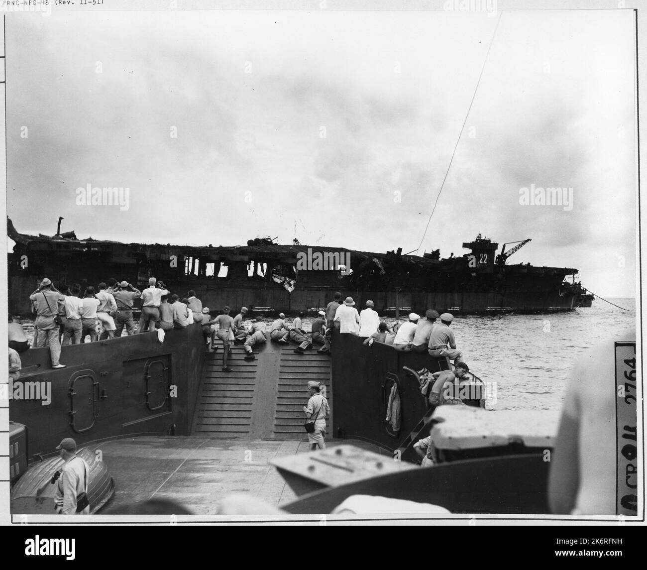 Foto - Korrespondenten sehen USS Independence während der Operation Crossroads'Korrespondenten sehen USS Independence (CVL-22), die während der Operation Crossroads beschädigt wurde. Auf See.'. Stockfoto