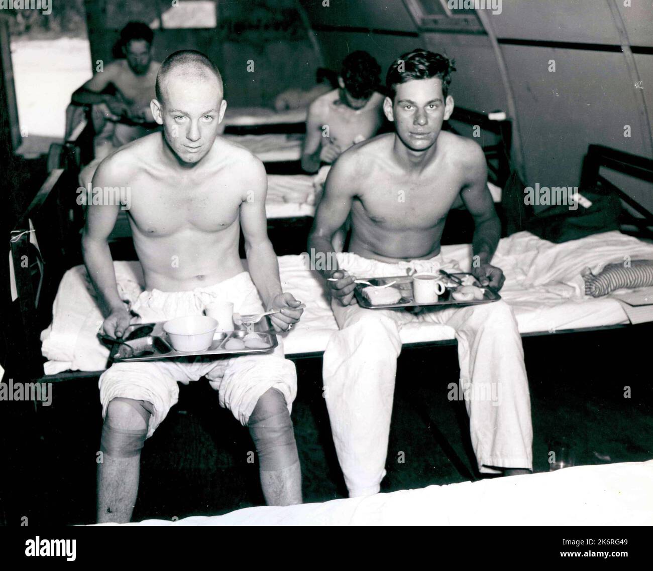 Foto der Überlebenden der USS Indianapolis (CA-35)"zwei Überlebende des Kreuzers USS Indianpolis (CA-35), der durch feindliche Aktionen im philippinischen Meer verloren wurde, werden kurz nach der Rettung in einem Peleliu-Krankenhaus auf den philippinischen Inseln gezeigt. Von links nach rechts: Joseph A. Jacouemot, S2/c, und Richard P. Thelen, S2/c.'. Stockfoto