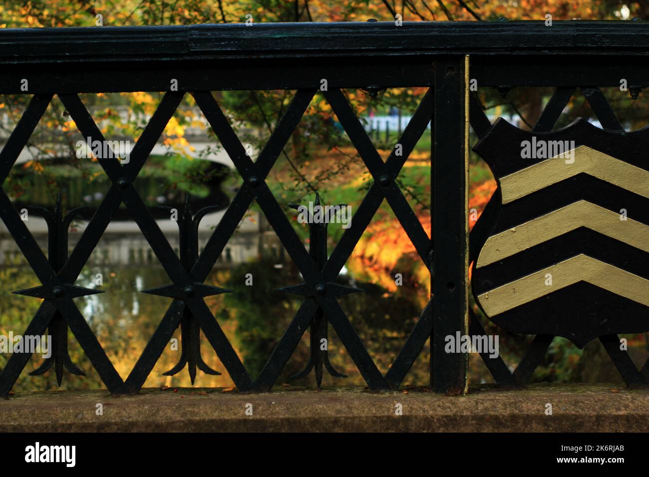 Gold nach oben Chevrons auf einem schwarzen Schild auf einer Brücke in Roath Park, Cardiff, Wales Stockfoto