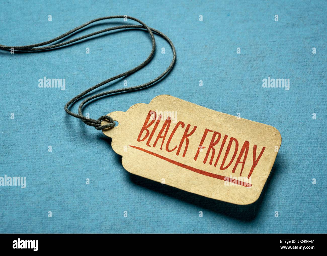 Black Friday sign - ein Papierpreisschild mit einer Garnierung gegen Texturpapier, Herbstferien und Einkaufskonzept Stockfoto