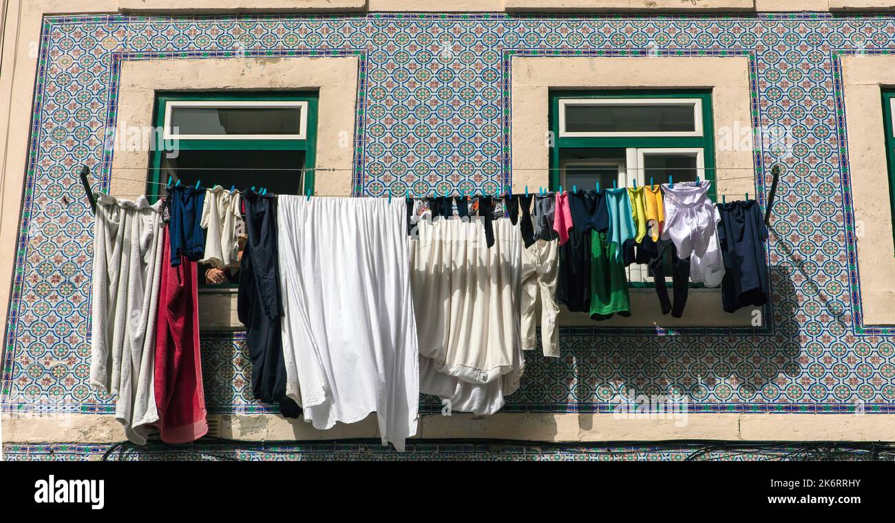 Wäsche waschen, die an Wäscheleinen vor den Fenstern in Bario Alto, Lissabon, Portugal hängt, um sie zu trocknen Stockfoto
