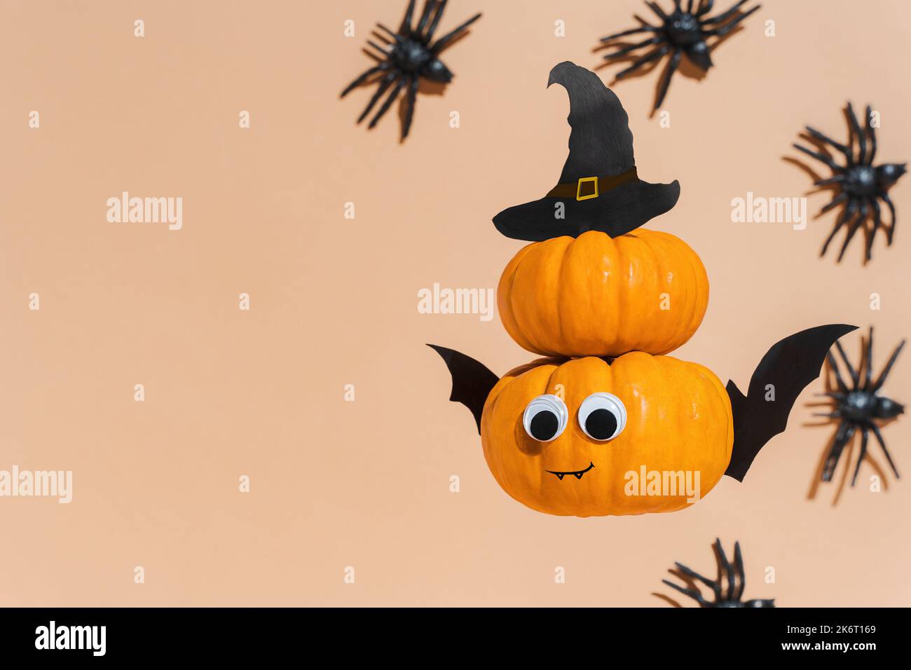 Deko für Halloween Kids Party - fliegender niedlicher Kürbiskopf mit Augen und witzigem Gesicht. Kürbismonster, Hexe, Vampir, krabbelnde Spinnen. Speicherplatz kopieren Stockfoto