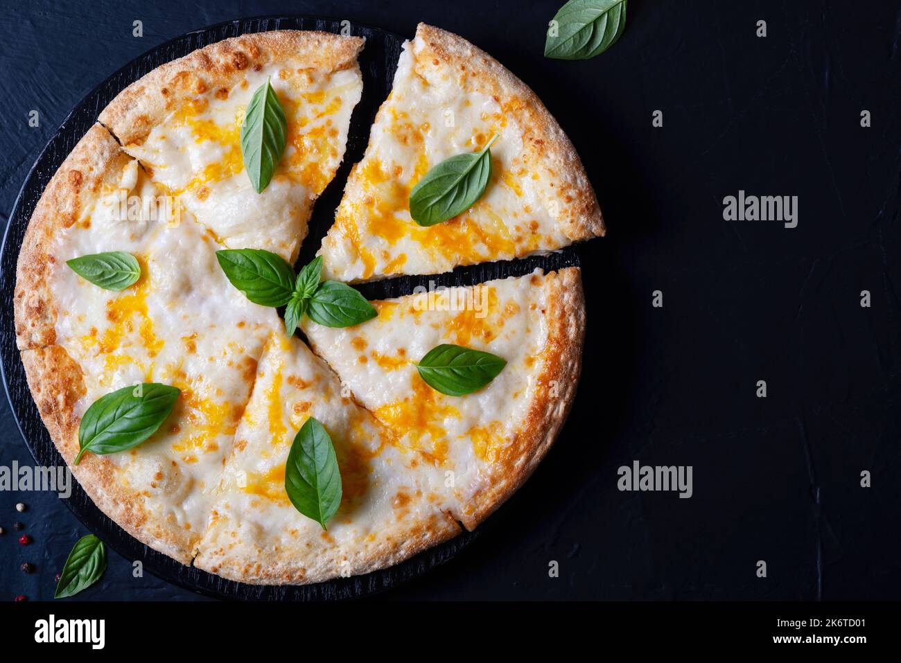 Italienische Pizza Margherita mit Käse und Basilikum auf schwarzem Betontisch Draufsicht Stockfoto