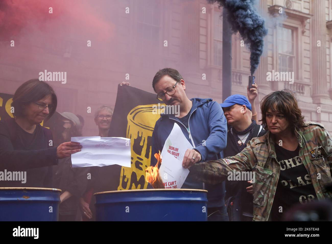 London, Großbritannien. 14. Oktober 2022. Ein Protestler der Aussterbungskampagne verbrennt eine Energierechnung, während die Aktivisten vor der Downing Street gegen die Klimakrise und steigende Energiekosten demonstrieren. Kredit: SOPA Images Limited/Alamy Live Nachrichten Stockfoto