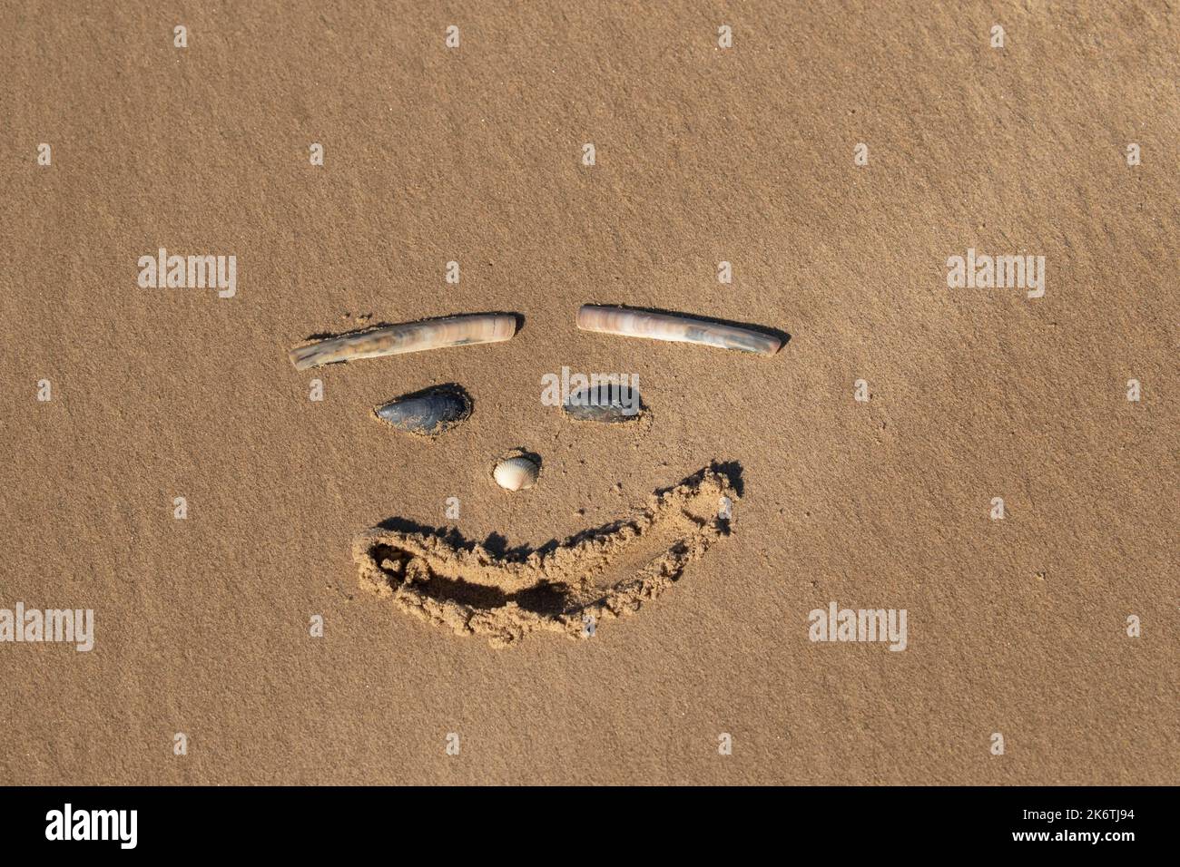 Zeichnung eines menschlichen Gesichts im Sand am Strand, Norfolk, England, Vereinigtes Königreich Stockfoto