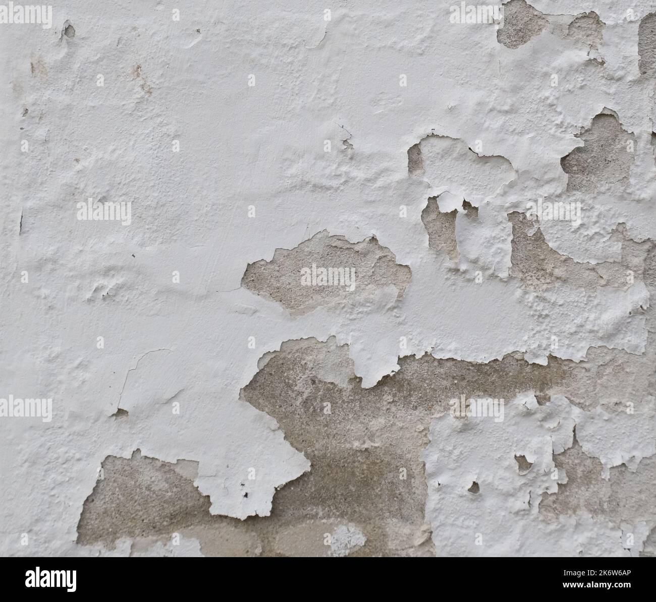 Hintergrund der abblätternden weißen Farbe an einer alten Wand. Stockfoto