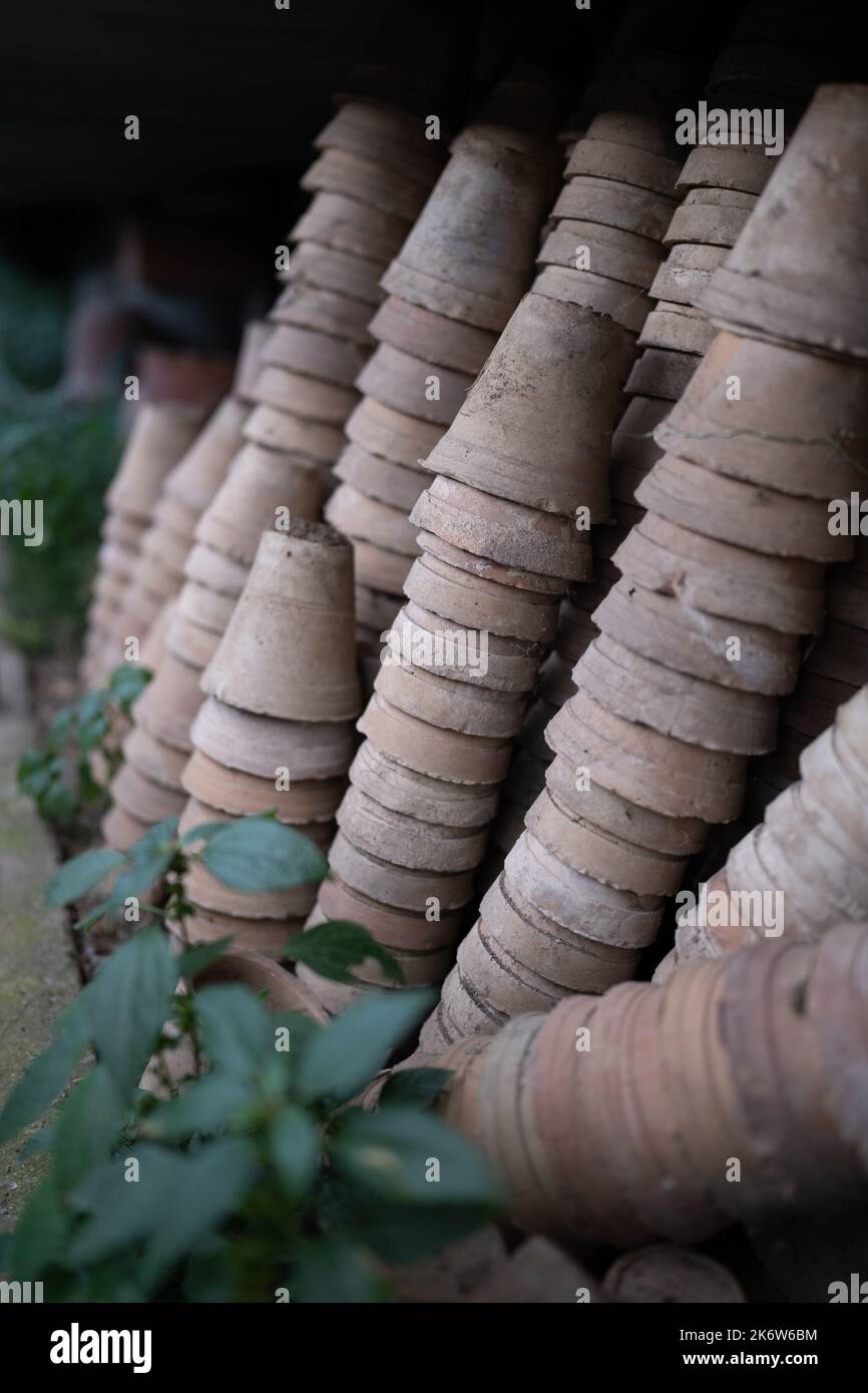Nahaufnahme von Stapeln alter verwitterter Terrakotta-Blumentöpfe im Gartenschuppen Stockfoto