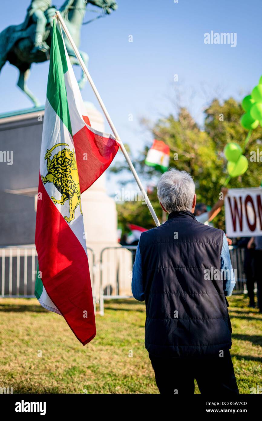 Washington DC, USA. 15. Oktober 2022. Ein Mann hält die iranische Flagge (mit dem Symbol der Pahlavi-Dynastie) beim Mahsa-Akini-Protest im Stanton Park. Die iranische Gemeinde Washington, DC, traf sich im Stanton Park als Teil einer größeren Serie von jüngsten Protesten in der ganzen Welt nach der Tötung von Mahsa Amini. Die Proteste konzentrieren sich auf den Kampf für die Gleichstellung der Frauen im Iran, nachdem Amini nach ihrer Verhaftung in einem Krankenhaus in Teheran starb, weil sie ihren Hijab nicht getragen hatte. Kredit: SOPA Images Limited/Alamy Live Nachrichten Stockfoto