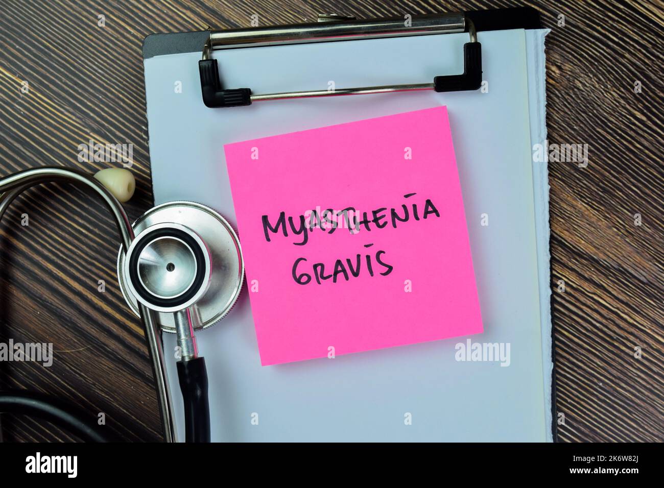 Konzept von Myasthenia Gravis Schreiben Sie auf Haftnotizen mit Stethoskop isoliert auf Holztisch. Stockfoto