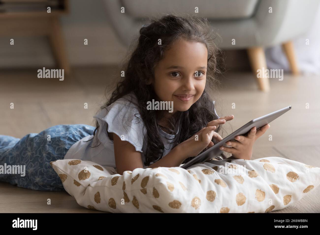 Schöne kleine indische Mädchen mit digitalen Tablet zu Hause Stockfoto