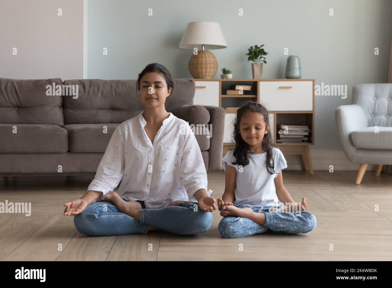 Stille indische Frau und Vorschulkinder meditieren drinnen sitzen Stockfoto