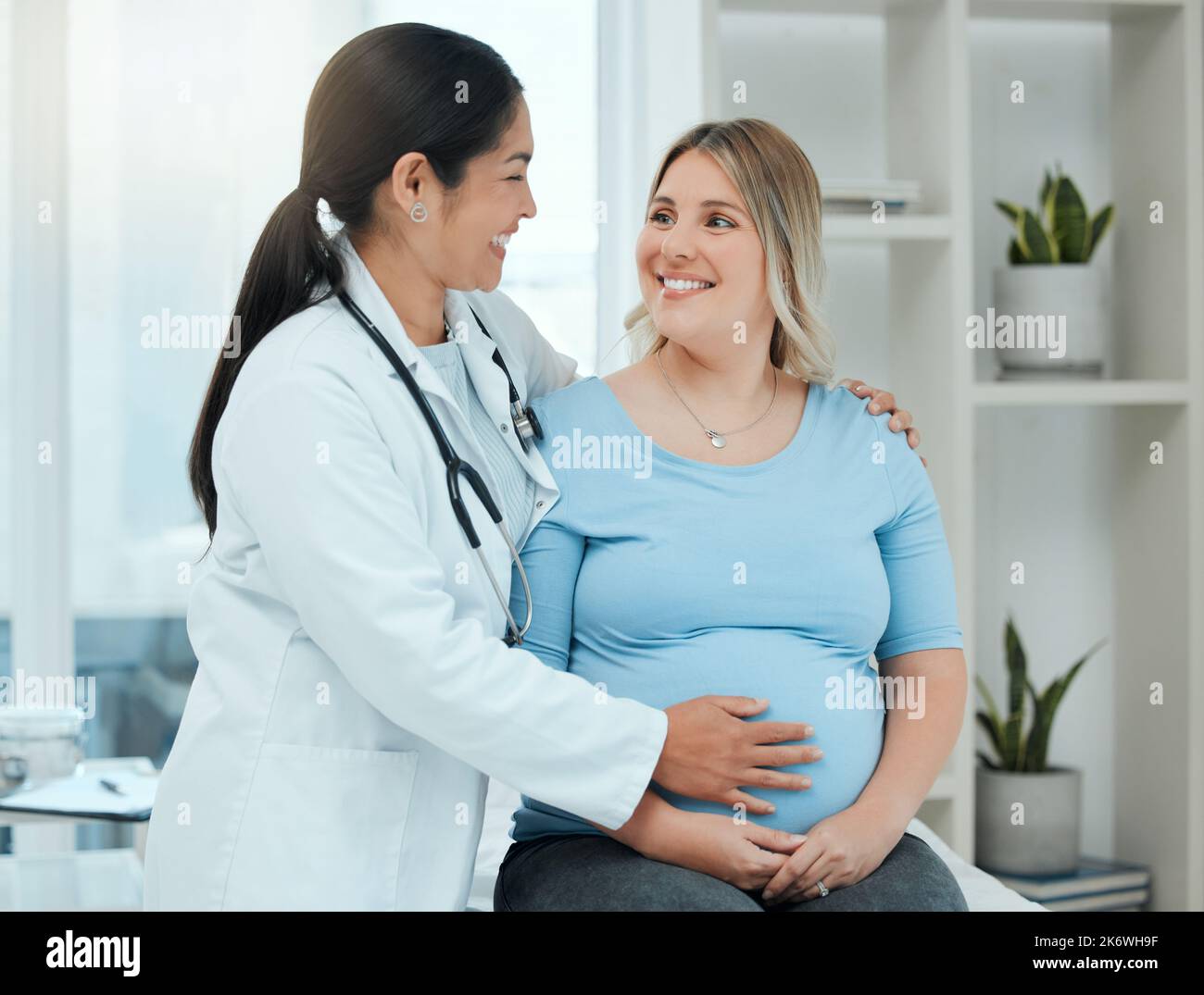 Nun werden mit wöchentlichen Untersuchungen, bis Sie liefern. Ein Arzt während einer Konsultation mit einer Schwangeren in einer Klinik. Stockfoto