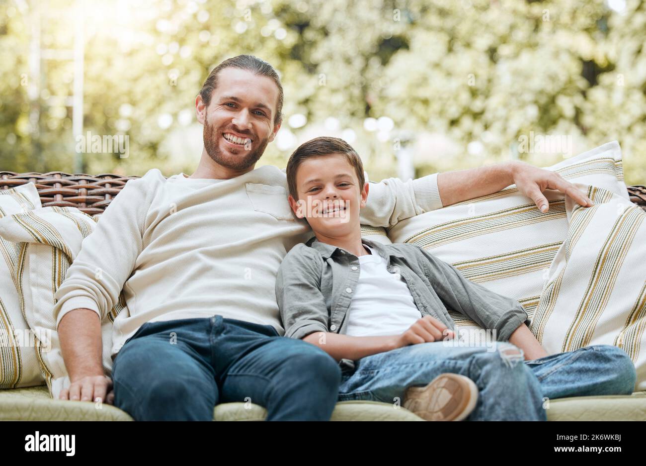 Es war sehr komfortabel. Ein hübscher junger Mann, der mit seinem Sohn draußen sitzt. Stockfoto