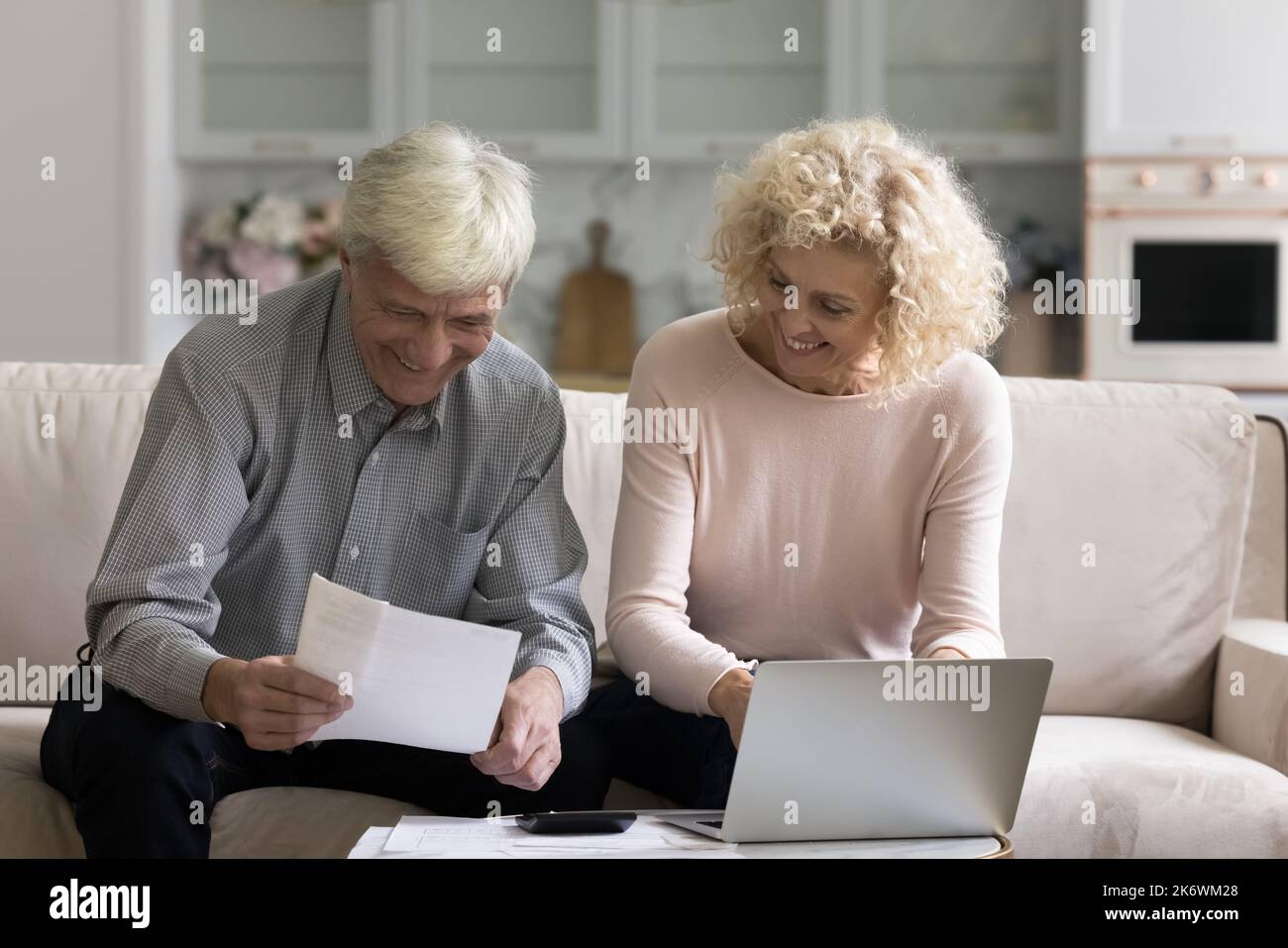 Das ältere Paar fühlt sich mit genügend Geld zufrieden, das monatliche Rechnungen zahlt Stockfoto