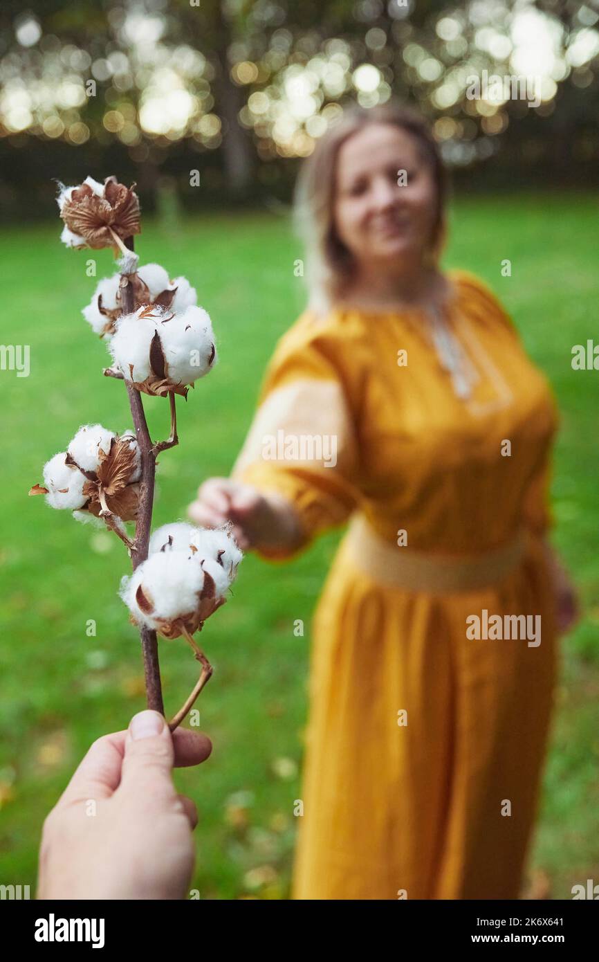 Ein Mann gibt einer ukrainischen Frau einen Baumwollzweig Stockfoto