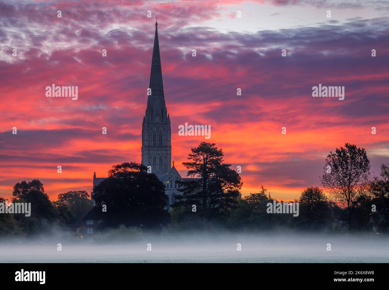 Oktober nebliger Morgenaufgang hinter der Salisbury Cathedral von den Harnham Water Meadows Wiltshire Südwesten Englands Stockfoto