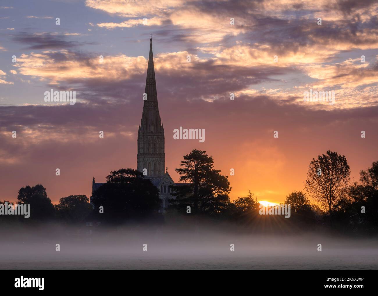 Oktober nebliger Morgenaufgang hinter der Salisbury Cathedral von den Harnham Water Meadows Wiltshire Südwesten Englands Stockfoto