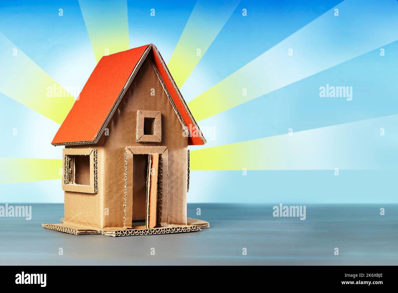 Ein Haus Handwerk aus Pappe auf einem blauen Himmel Illustration Hintergrund Stockfoto