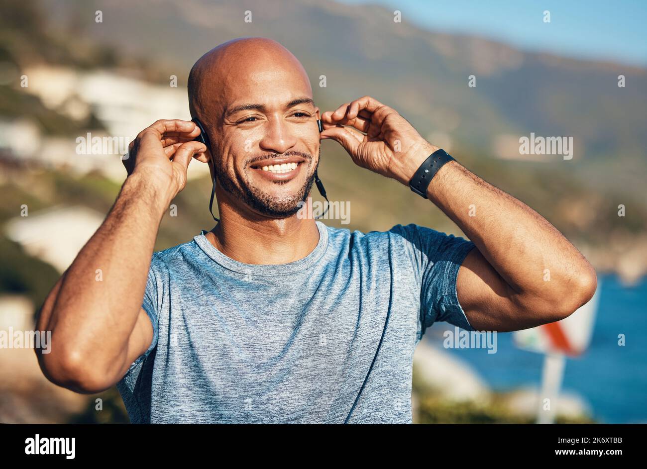 Dieser Schmerzbereich trennt einen Champion. Ein sportlicher junger Mann, der während des Trainings Ohrhörer trägt. Stockfoto