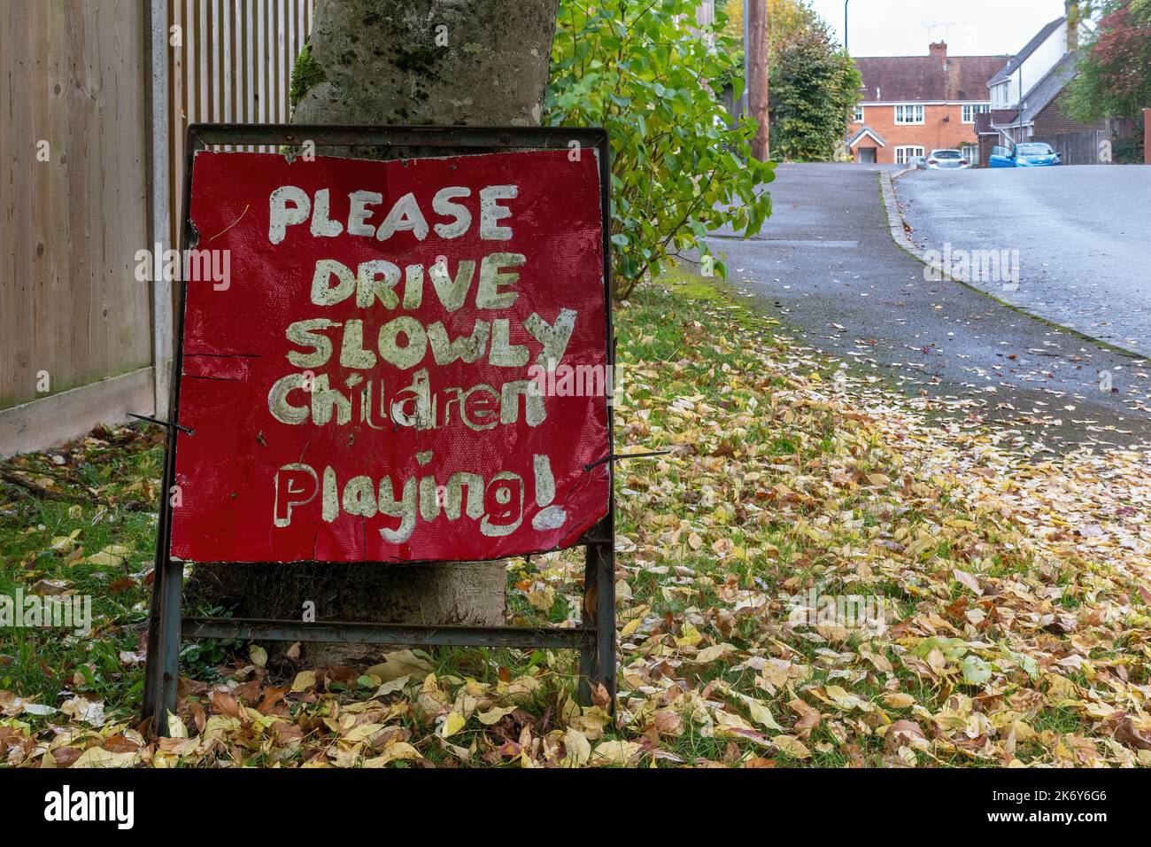 Bitte fahren Sie langsam spielende Kinder, rotes Straßenschild in Wohngebiet, Großbritannien Stockfoto