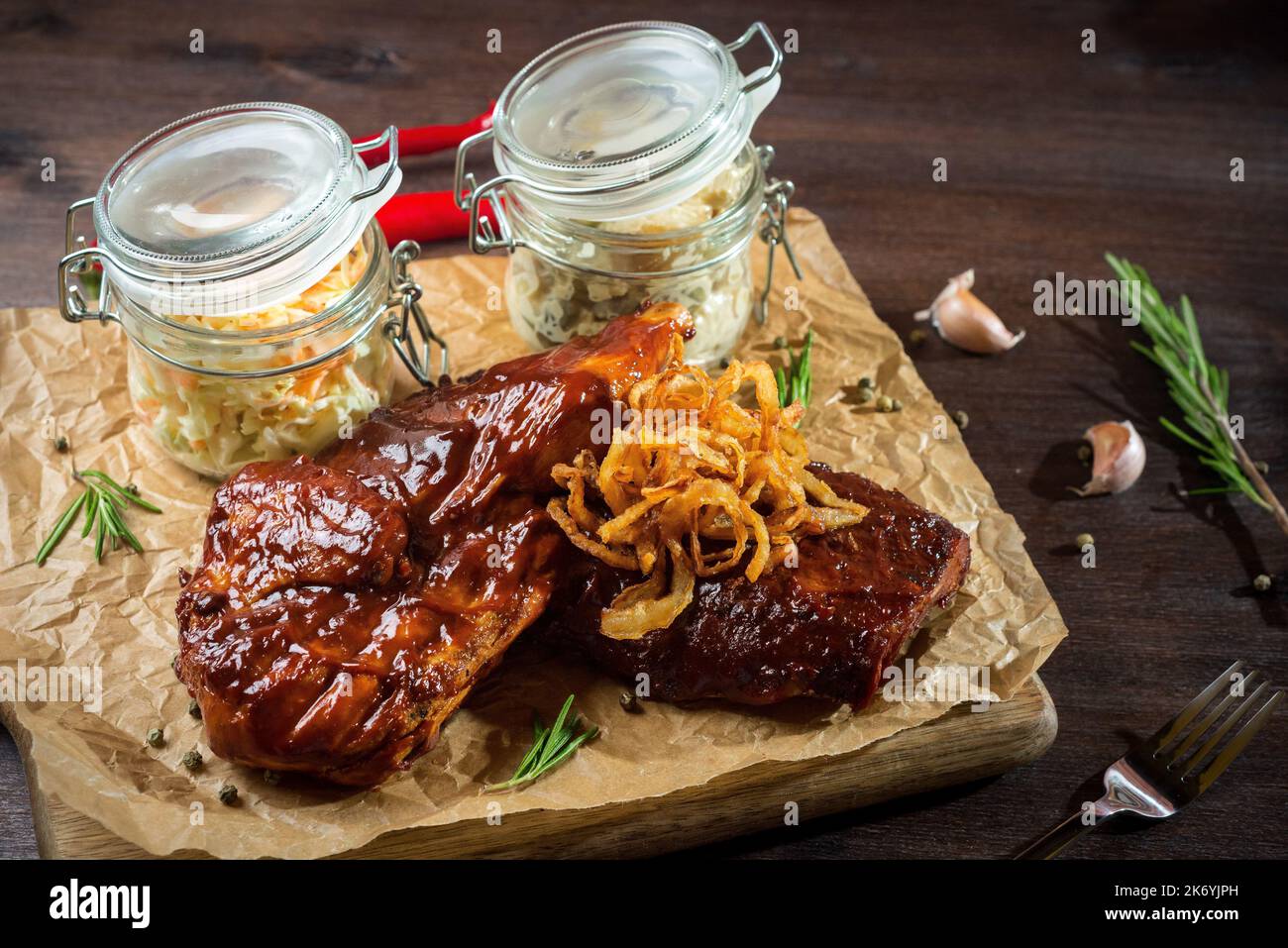 Zwei Steaks mit Grillsauce, gebratene Zwiebeln und zwei Gläser ...