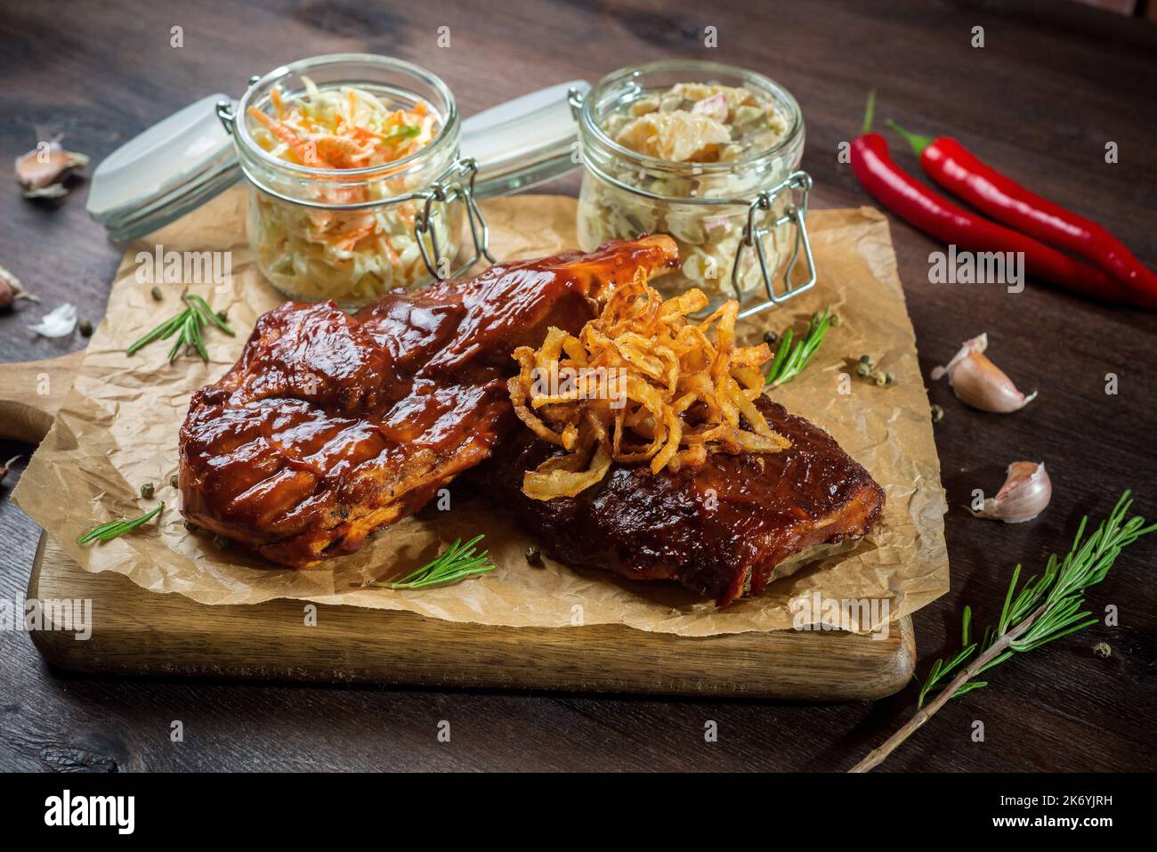 Zwei Steaks mit Grillsauce, gebratene Zwiebeln und zwei Gläser ...