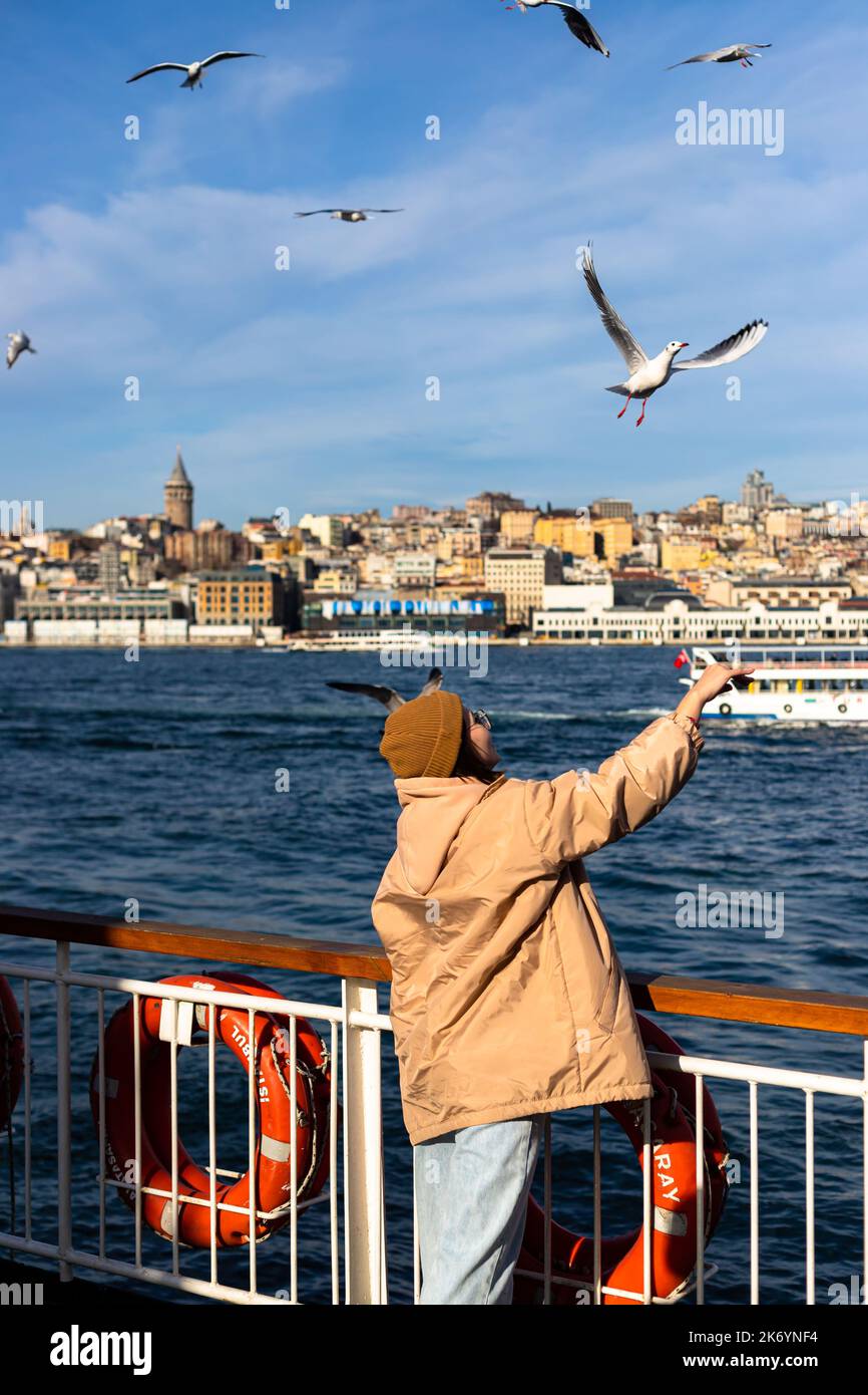 istanbul, Türkei Nowember 12 2021 : junge Touristen, die Möwen auf der Fähre essen, touristische Aktivitäten Stockfoto