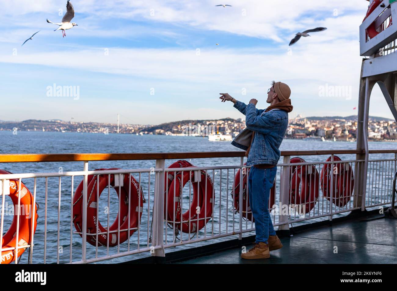 istanbul, Türkei Nowember 12 2021 : junge Touristen, die Möwen auf der Fähre essen, touristische Aktivitäten Stockfoto