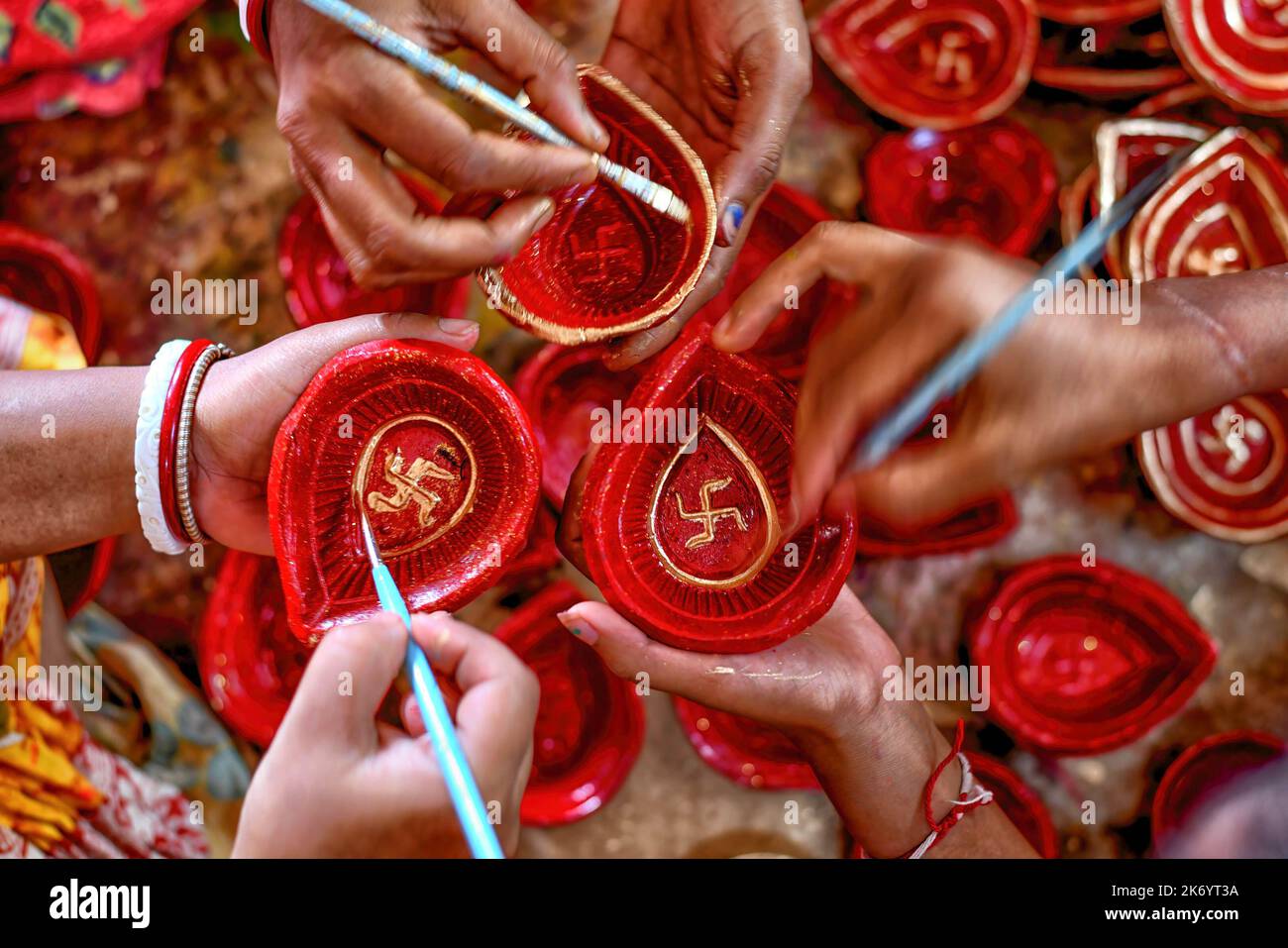 Vor dem Diwali Festival in Indien sahen die Arbeiter Farben auf irdenen Lampen zum Verkauf anmalen. Deepavali oder Dipavali ist ein vierfünftägiges Lichterfest, das von Hindus, Jains, Sikhs und einigen Buddhisten in jedem Herbst auf der ganzen Welt gefeiert wird. Stockfoto