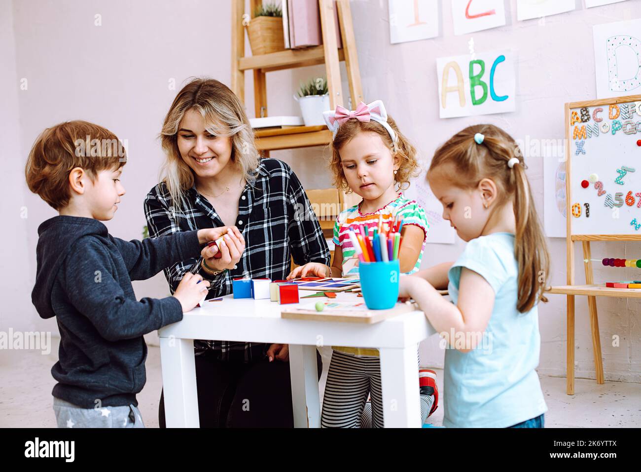Lehrer mit Kindern haben Spaß und spielen, lernen Alphabet und Zahlen von Künsten in der Kinderentwicklung un Schule Stockfoto