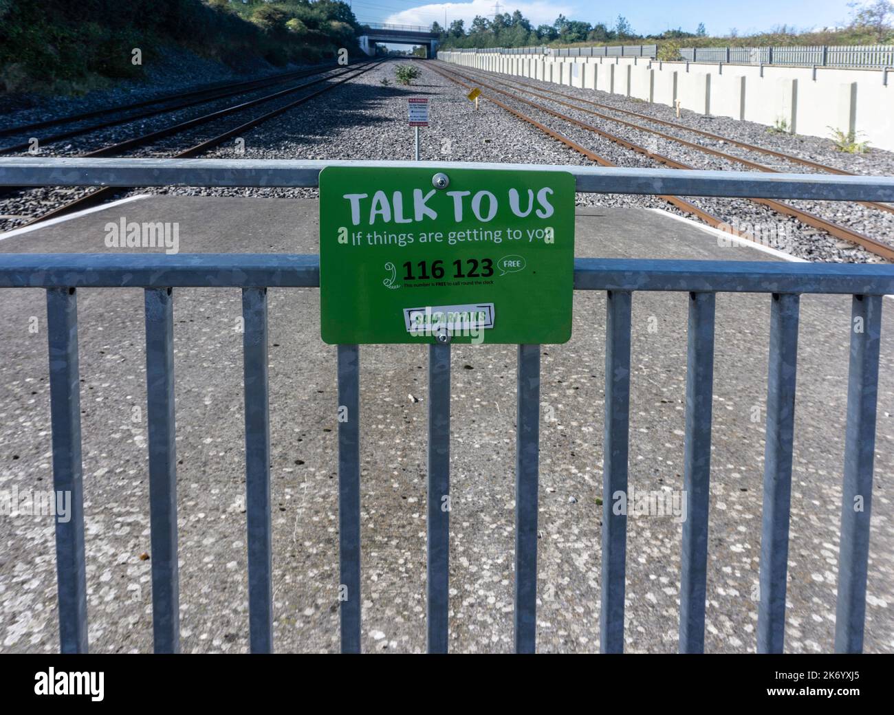 Ein Schild in der Nähe einer Eisenbahnlinie in Dublin, Irland, für die Samariter, auf dem unruhige Menschen aufgefordert werden, mit den Samaritanern zu sprechen, Stockfoto