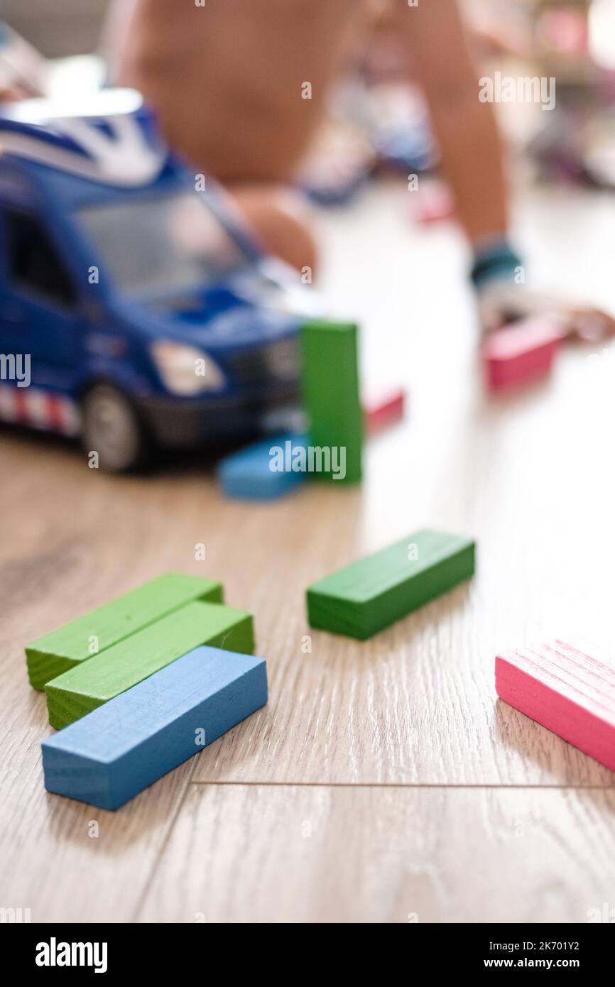 Einige bunte Spielzeughölzer und ein Van, der auf einem Hartholzboden auf einem Indoor-Spielplatz zusammenbricht Stockfoto