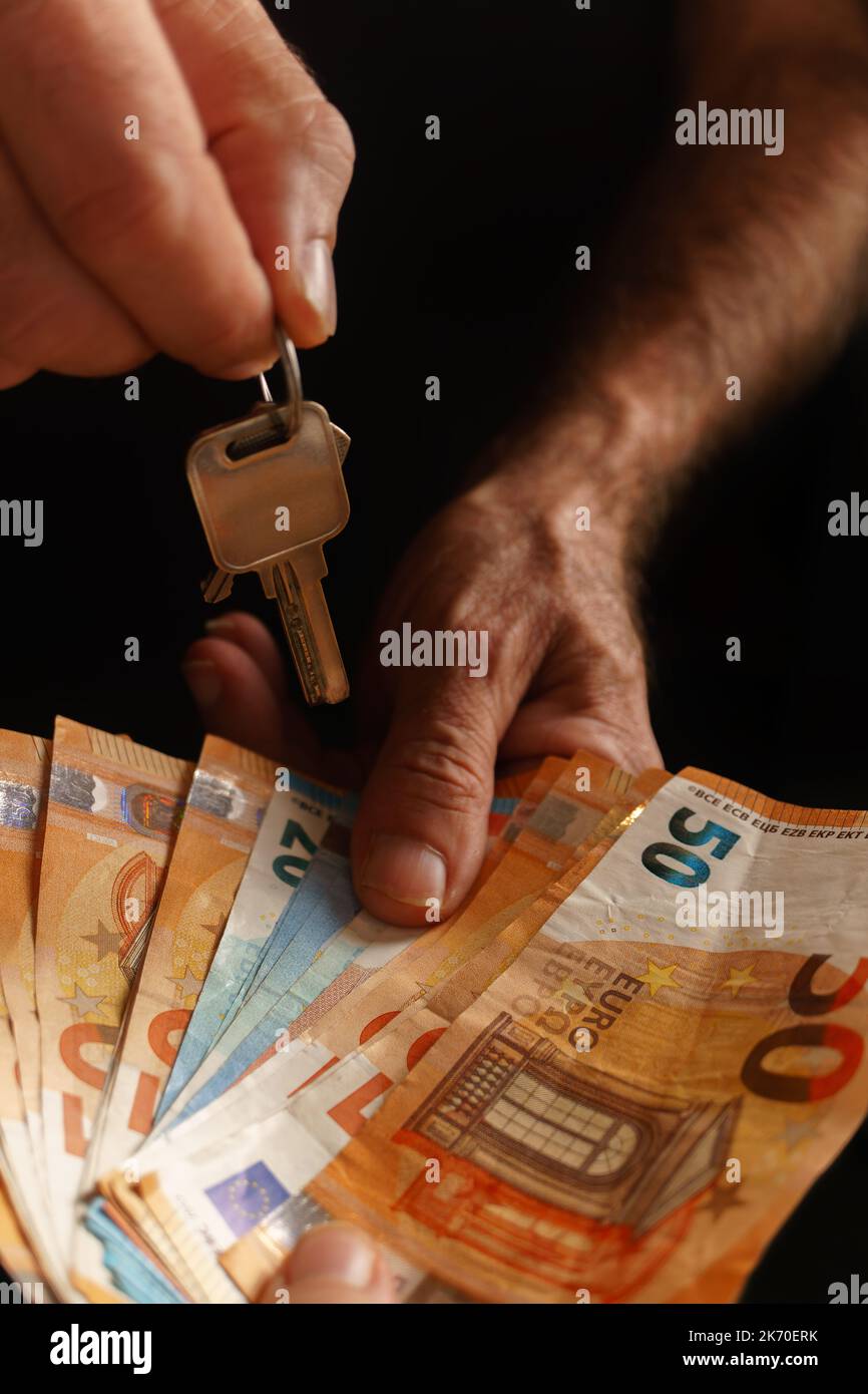 Eine Frau übergab Geld und ein Mann überreichte die Schlüssel zu einem Haus Stockfoto