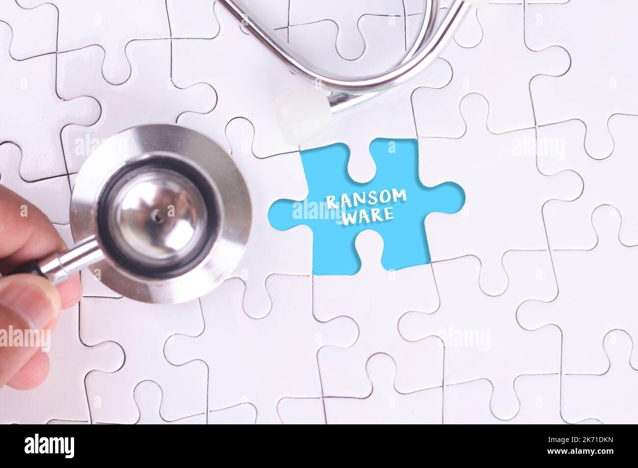 Arzt hält ein Stethoskop auf fehlende Puzzle MIT RANSOMWARE WORT Stockfoto