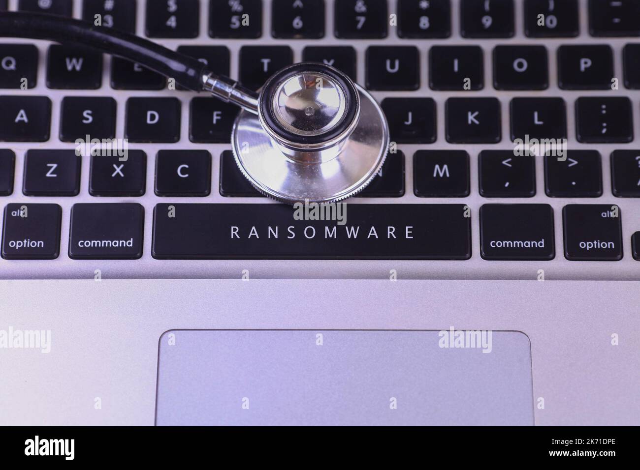 Nahaufnahme von Stethoskop und RANSOMWARE auf Laptop-Tastatur geschrieben Stockfoto