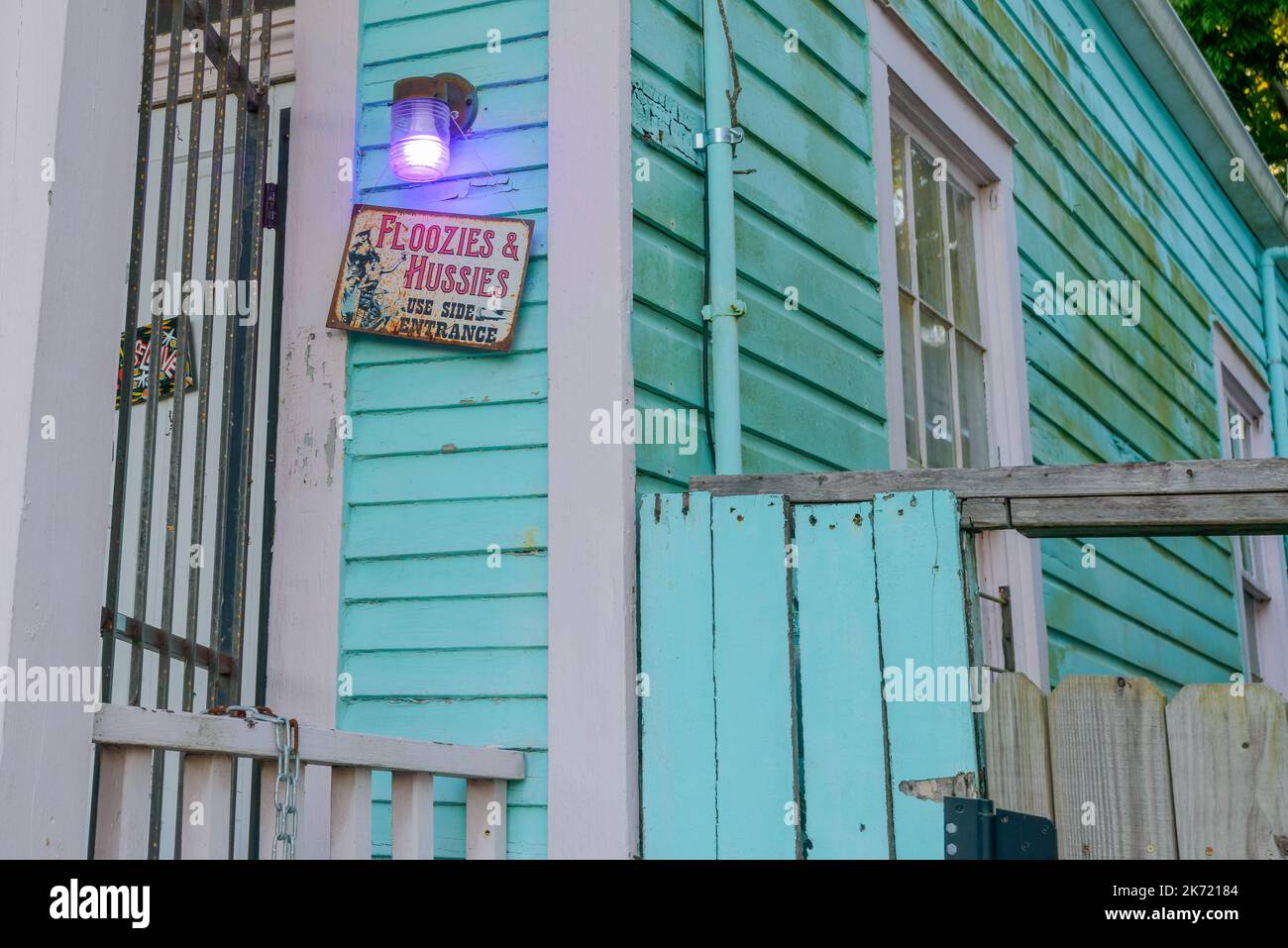 NEW ORLEANS, LA, USA - 13. OKTOBER 2022: Schild „Floozies and Hussies use side entrance“ vor dem Haus in Uptown Stockfoto