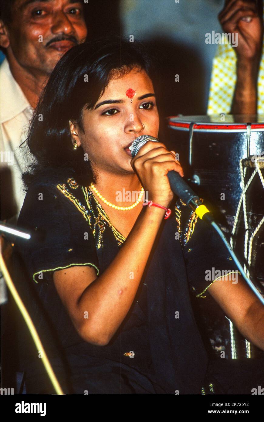 Eine junge Sängerin tritt bei einem Garba oder Karneval in Rajkot, Gujarat, Indien, auf Stockfoto