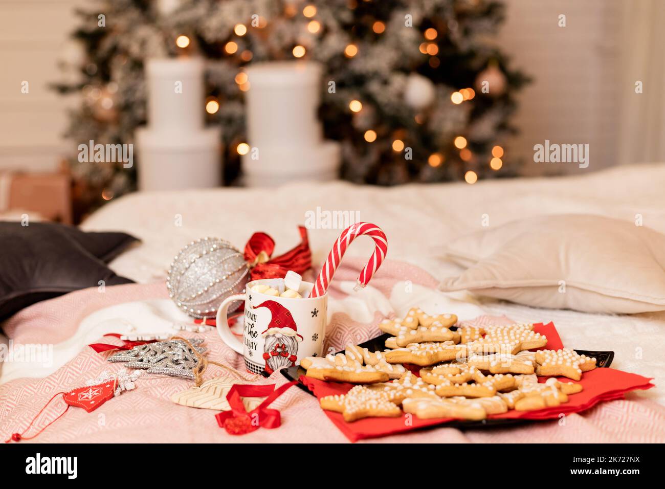 Weihnachtskekse mit Weihnachtsschmuck auf dem Bett im Innenraum Stockfoto