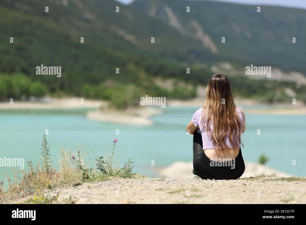 Rückansicht einer Frau, die einen schönen See betrachtete Stockfoto