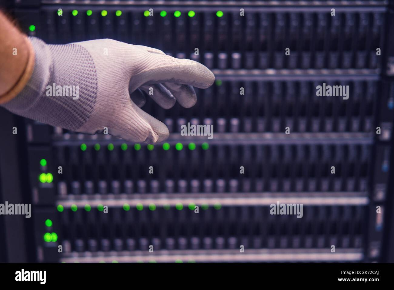 Die Hand eines männlichen Ingenieurs an einem Datenspeicherserver, Nahaufnahme Stockfoto