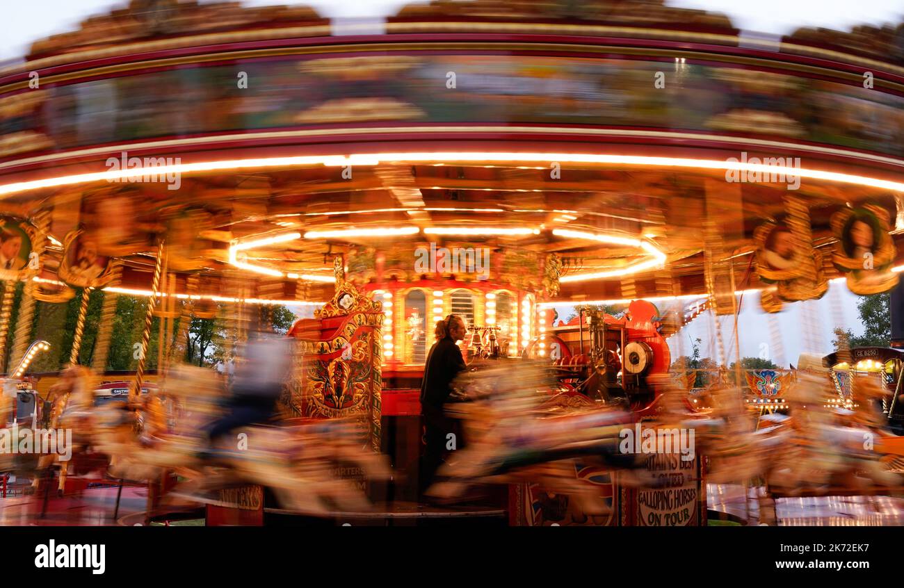 Ein Mitglied der Carters Steam Fair betreibt die Jubilee Steam Galopper, während Mitglieder der Öffentlichkeit sie an ihrem letzten Halt im Prospect Park in Reading besuchen. Die Carters Steam Fair ist ein traditioneller englischer Wandermarkt mit Fahrgeschäften aus den Jahren 1890s bis 1960. Die 1977 von John und Anna Carter begonnene Messe befindet sich nun auf der letzten Etappe ihrer letzten Tournee, nachdem sie in den letzten 45 Jahren durch Großbritannien gereist war, und steht zum Verkauf, in der Hoffnung, einen festen Standort mit einem neuen Besitzer zu finden. Bilddatum: Sonntag, 16. Oktober 2022. Stockfoto