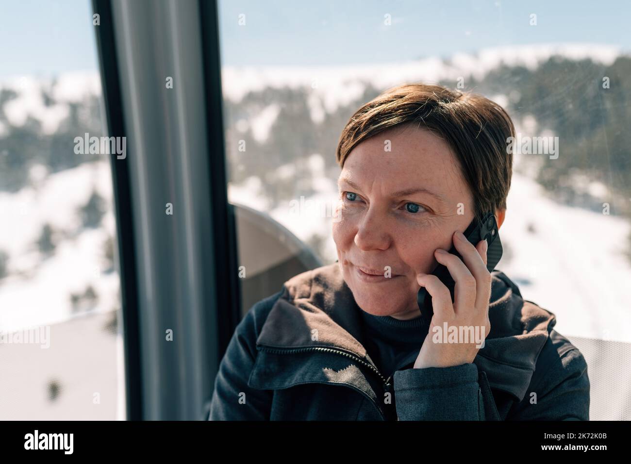 Frau, die im Winter mit der Gondel am Zlatibor Berg telefoniert, selektiver Fokus Stockfoto