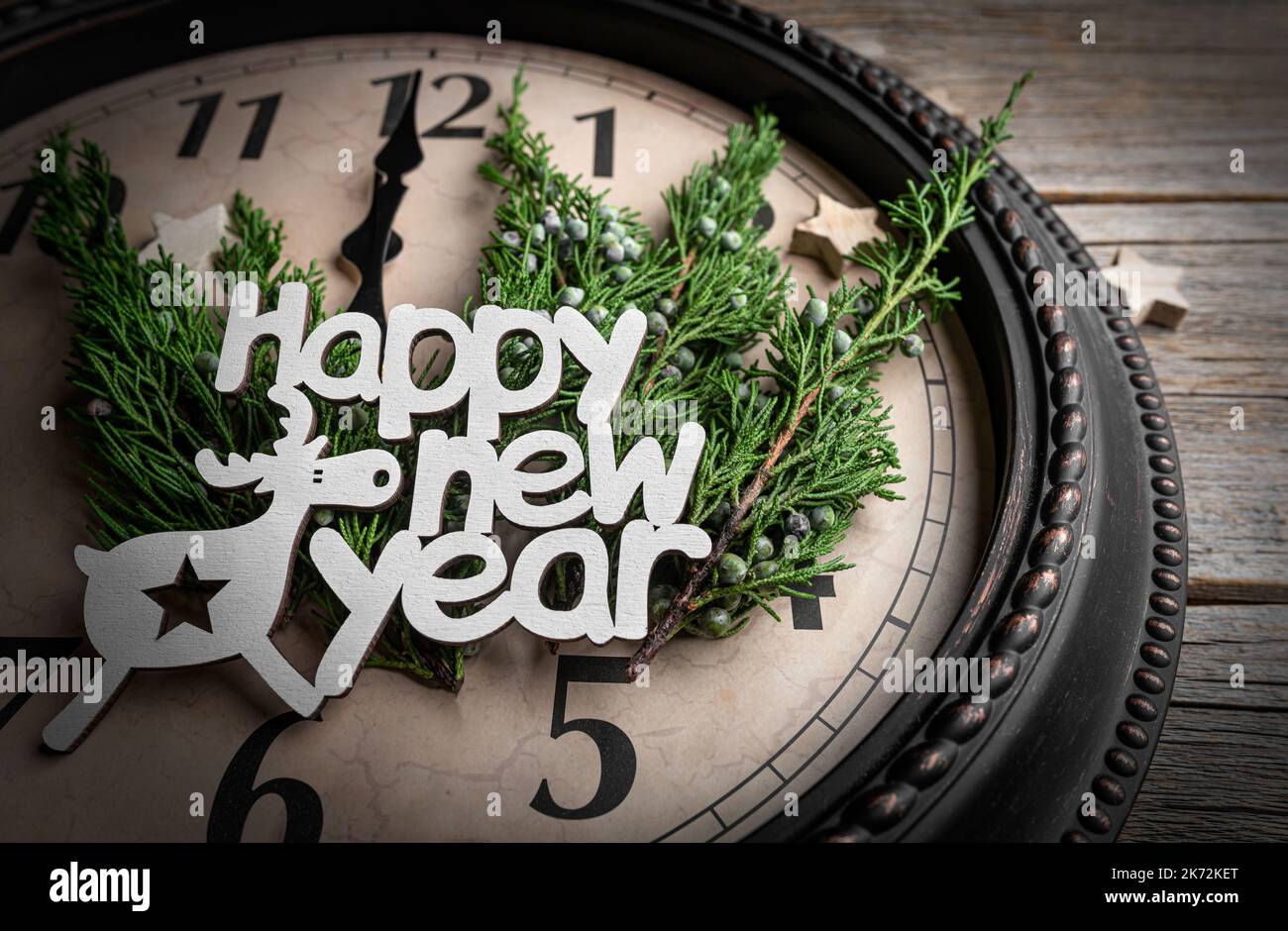 Die Inschrift Frohes Neues Jahr auf dem Hintergrund der Uhr. Stockfoto